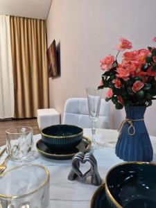 a table with a blue vase with flowers in it at Love Nest in Almaty