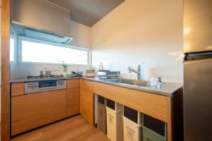 a kitchen with wooden cabinets and a sink and a window at Sakura Moana - Vacation STAY 06385v in Fukaura