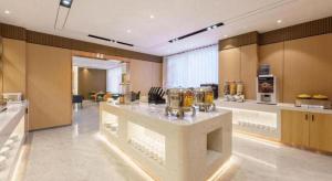 a large kitchen with a large island in a room at Jinjiang Inn - Xishan Road in Dalian