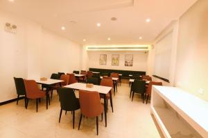 a restaurant with tables and chairs in a room at GreenTree Inn Jiangsu Xuzhou Western 3rd Ring Road Xiyuan Express Hotel in Xuzhou