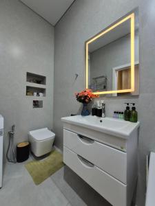 a bathroom with a white sink and a mirror at Love Nest in Almaty +46 photos