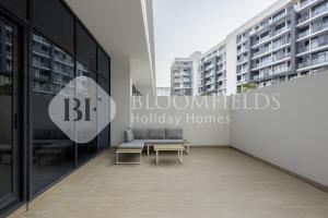 a room with a couch and a table in a building at Bloomfields Executive 3br Th The Gate Masdar in Abu Dhabi