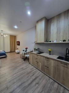 a large kitchen with wooden cabinets and a table at Love Nest in Almaty