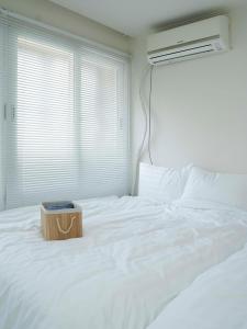 ein weißes Bett mit einer Holzkiste darauf in der Unterkunft 부산 광안리 비앤비 스테이 in Busan + 31 Fotos