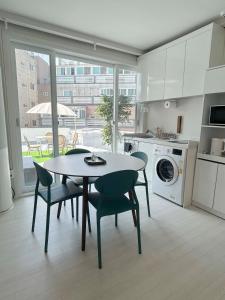 eine Küche mit einem Tisch und Stühlen sowie eine Küche mit einem Fenster in der Unterkunft 부산 광안리 비앤비 스테이 in Busan