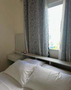 a bedroom with a bed and a window with curtains at STO Tower A Hulhumale Phase 2 in Hulhumale