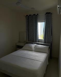 a bedroom with a white bed with a window at STO Tower A Hulhumale Phase 2 in Hulhumale