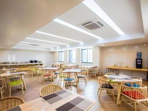 an empty classroom with tables and chairs at GreenTree Inn Jiaxing Qixing Town Goverment in Jiashan
