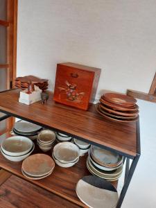 a shelf with a bunch of plates and a clock at ゲストハウス凪季のやど in Nachikatsuura +22 photos