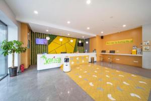 a lobby with a waiting area with a vita waiting room at Vatica Hefei Feidong County Yuzhou Central Square Hotel in Feidong