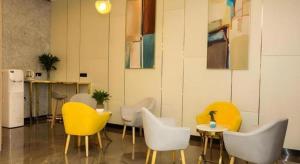 a room with yellow and white chairs and a table at GreenTree Inn Suzhou Changshu Southeast Development Zone Southeast Avenue in Gujiashuigou