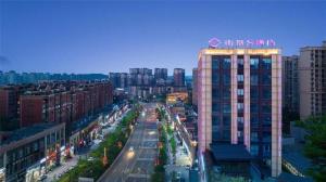 une rue de la ville avec un bâtiment muni d'un panneau. dans l'établissement Shanshui S Hotel Zizhong City Mdl, à Shuinan