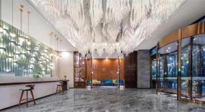 un hall d'entrée avec un grand lustre dans un immeuble dans l'établissement Shanshui S Hotel Zizhong City Mdl, à Shuinan