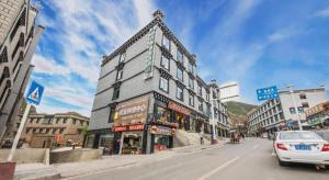 a building on the corner of a city street at GreenTree Inn Ganzi Daochengzhou Scenic Area in Kanggar