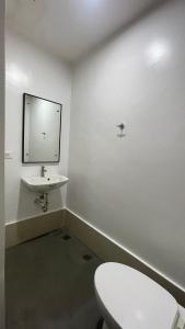 Un baño con un inodoro blanco y un lavabo. en Romantic 2BR Haven with Gentle Lighting, en Mandurriao 5 fotos más