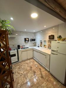 eine Küche mit weißen Schränken und einem weißen Kühlschrank in der Unterkunft Complejo San isidro in San Rafael