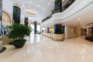 a large lobby with a potted plant in a building at Dalian Liangyun Hotel in Dalian