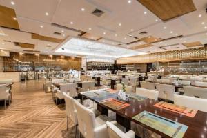 un restaurant avec une longue table et des chaises dans l'établissement Golden Eagle Summit Hotel Downtown, à Nankin