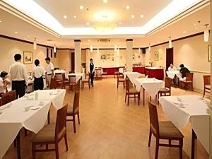 a restaurant with white tables and people standing in a room at GreenTree Inn Hotel - Nantong Hongming Plaza in Nantong