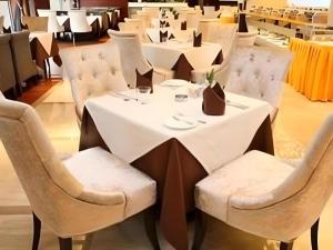 a table with white chairs and a white table cloth at Zhongshan Huahong Hotel in Zhongshan