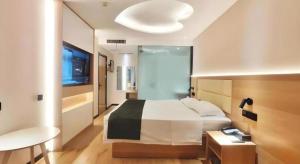 - une chambre avec un grand lit, un bureau et une télévision dans l'établissement GreenTree Inn Heze Railway Station Hotel, à Zhaolou 54 autres photos