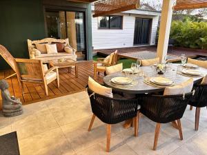 a patio with a table and chairs and a couch at Villa Parenthèse - Piscine & Bungalow - 8 Pers in Trois Bassins
