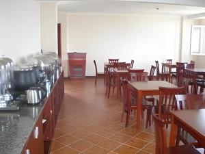 a restaurant with wooden tables and chairs and a counter at GreenTree Inn Weihai Port in Weihai