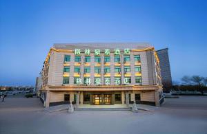 a large building with writing on the front of it at GreenTree Inn Puyang Pushang Huanghe Road in Zhongyuanyoutian