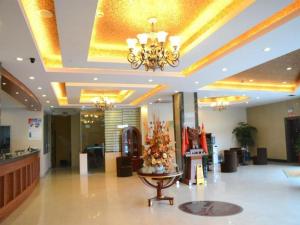 a lobby with a chandelier and a table in a building at GreenTree Inn Nantong Haian Kaifa District Express Hotel in Maotangqiao