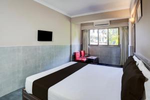 een slaapkamer met een groot bed en een raam bij Hotel O Calangute-Baga Crossway Formerly Rustic Village in Calangute +23 foto's