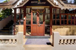 a building with a red door in front at Hotel O Calangute-Baga Crossway Formerly Rustic Village in Calangute