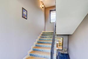 a staircase in a house with blue carpeting and a window at Hotel O Calangute-Baga Crossway Formerly Rustic Village in Calangute +23 photos
