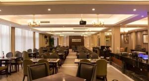 a restaurant with tables and chairs and a bar at Jinjiang Metropolo Shanghai Minhang in Shanghai