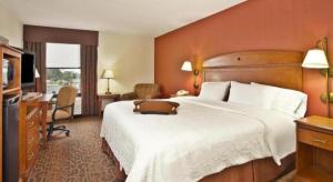 a hotel room with a large bed and a desk at Hampton Inn Anderson in Anderson +12 photos