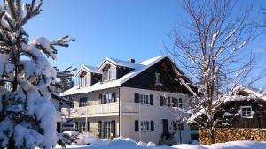 a white house with snow on the ground at Apartment Schreyegg in Seefeld
