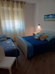 a bedroom with a bed and a chair in it at Appartamento Chiara in Roseto degli Abruzzi