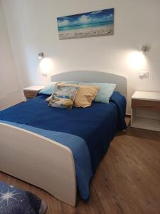 a bedroom with a bed with blue sheets and pillows at Appartamento Chiara in Roseto degli Abruzzi