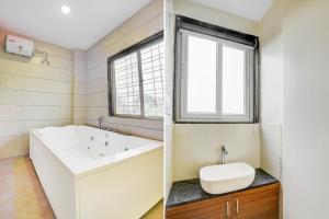 a bathroom with a tub and a sink and a window at Hotel O Elite Stay in Pune