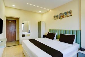 プネにあるHotel O Elite Stayの部屋の中に大きなベッドがある寝室