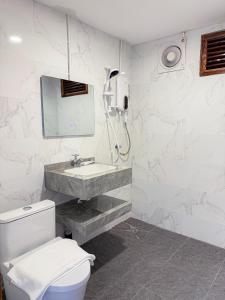 a white bathroom with a toilet and a sink at Mini Vangvieng Resort in Vang Vieng