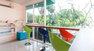 a room with colorful chairs in front of a window at Orchid Residence in Nakhon Si Thammarat