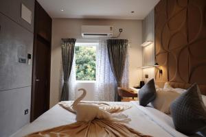 a hotel room with a bed with a swan on it at 23 Urban Suites, Hitech City in Hyderabad