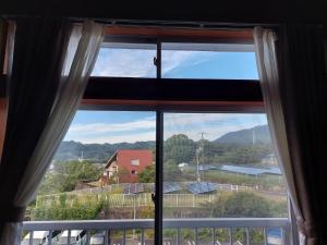 a window with a view of a mountain at ゲストハウス凪季のやど in Nachikatsuura