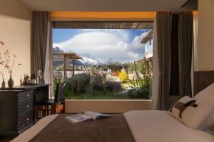 a bedroom with a large window with a mountain view at LiJiang Mountain Spring Resort in Baisha