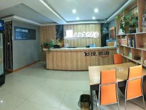 南京市にあるJun Hotel Jiangsu Nanjing Gulou District Gupinggangのカウンターとオレンジ色の椅子が置かれたレストラン