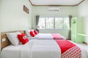 - 2 lits dans une chambre rouge et blanche dans l'établissement OYO 742 View Pruksa Resort, à Ban Hin Chang (2)