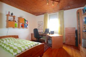 ein Schlafzimmer mit einem Bett und einem Schreibtisch mit einem Computer in der Unterkunft Private Rooms in Hannover