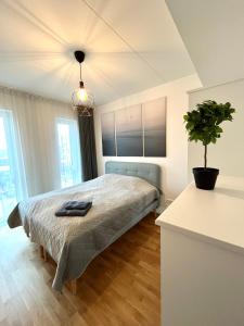Un dormitorio con una cama y una planta en maceta. en Nature & Comfort City Stay, en Tartu