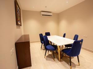a conference room with a table and blue chairs at فندق قمة البستان in Quai