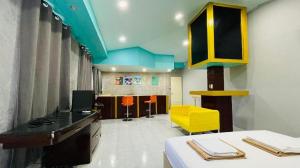a kitchen with yellow cabinets and a yellow chair in a room at Super Hostel in Nonthaburi